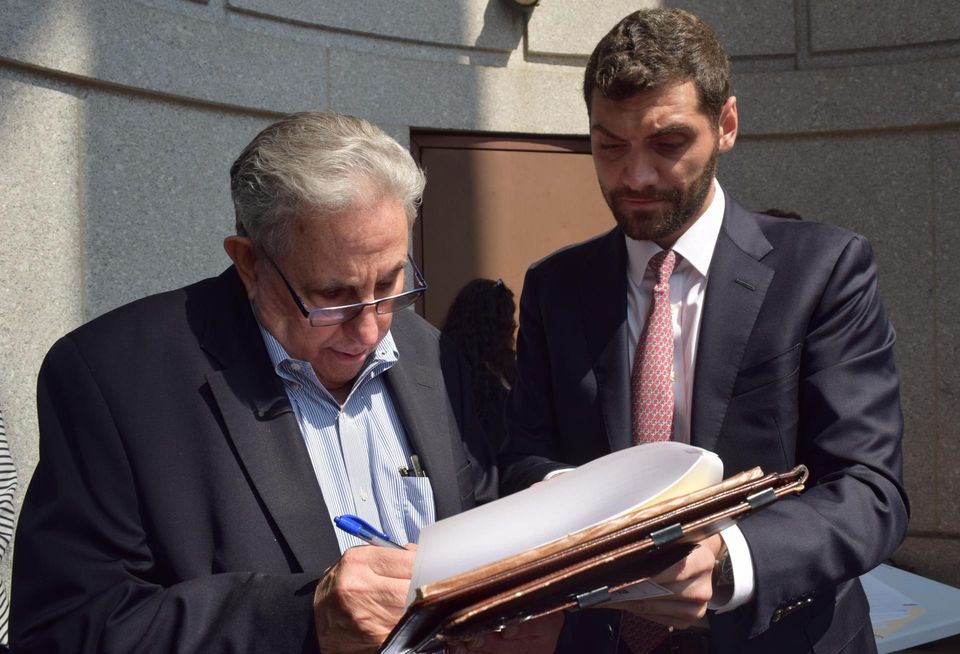 Jeff Gural signs paperwork for the Flatiron Building with auctioneer Matthew Mannion after entering the winning bid for the landmarked property's ownership.