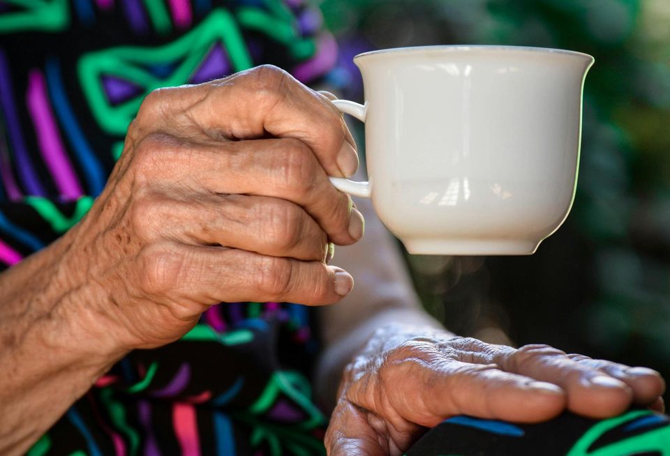 senior person holding a cup