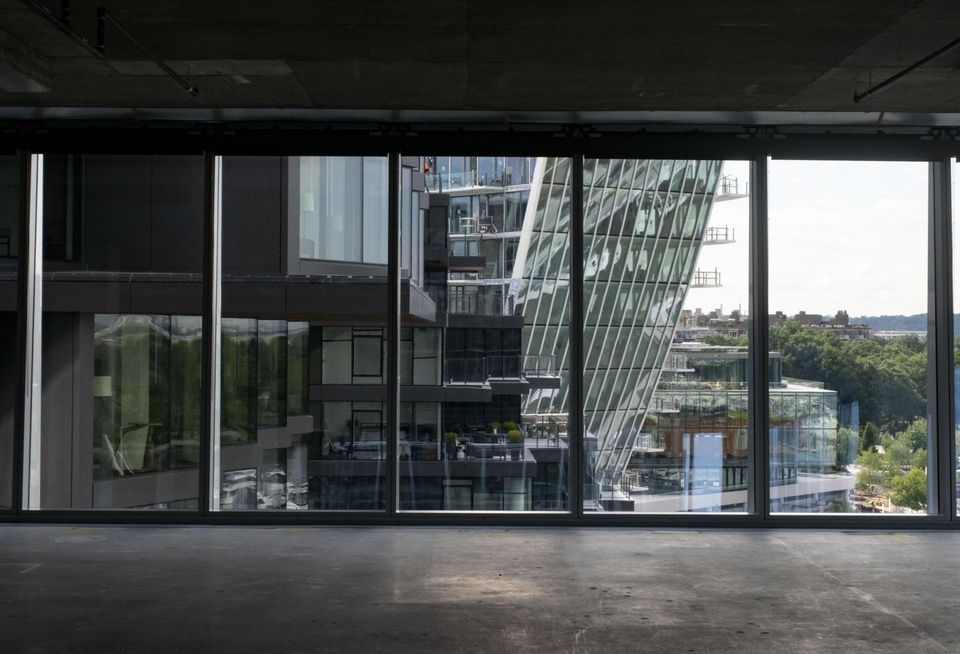 View looking out of raw office space toward The Pendry hotel, The Tides apartment building, and Amaris Condominium building.