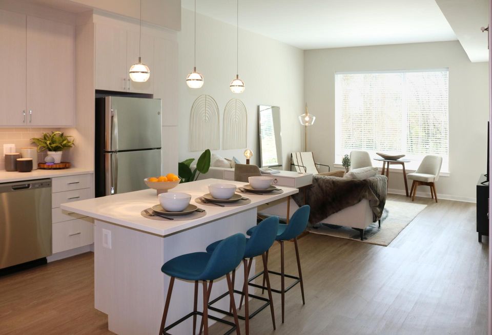Model unit in The Blake, featuring bar area in kitchen with seating and living area.