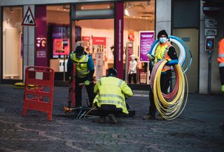 Technicians installing empty pipes for fast fiber internet.