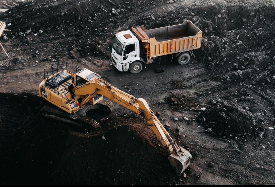 An excavator and truck at a construction site.