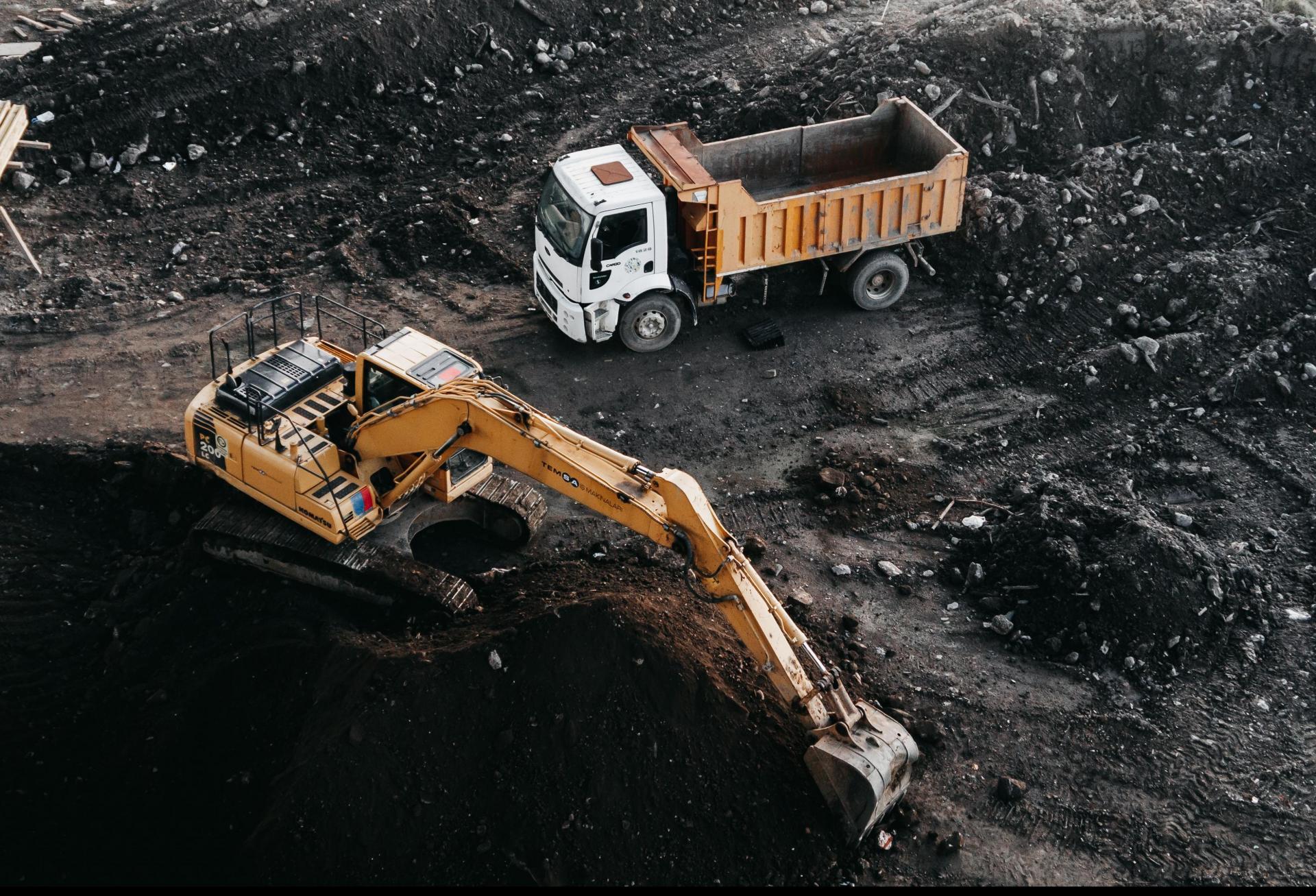 An excavator and truck at a construction site.