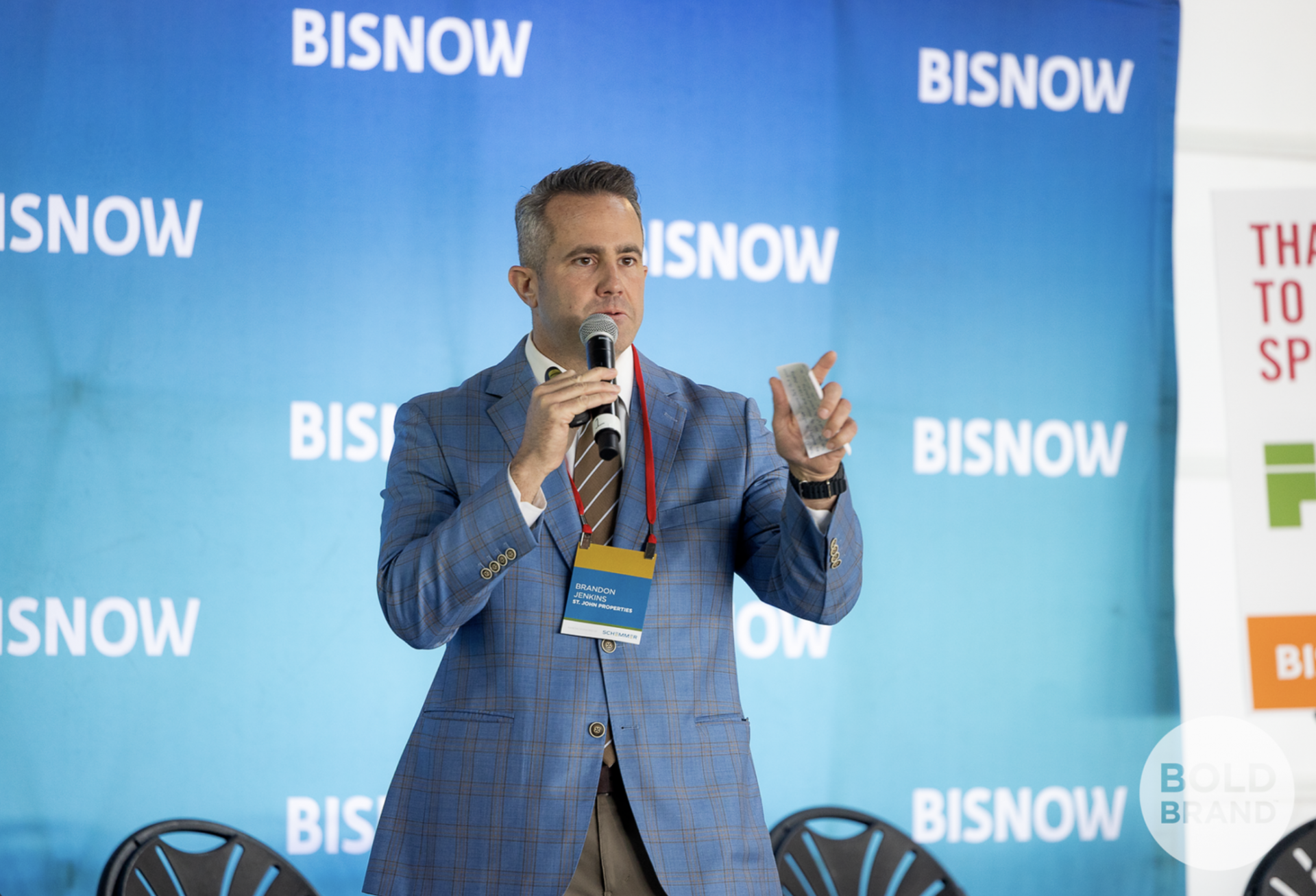 A high-resolution image of Brandon Jenkins speaking at Bisnow's industrial event