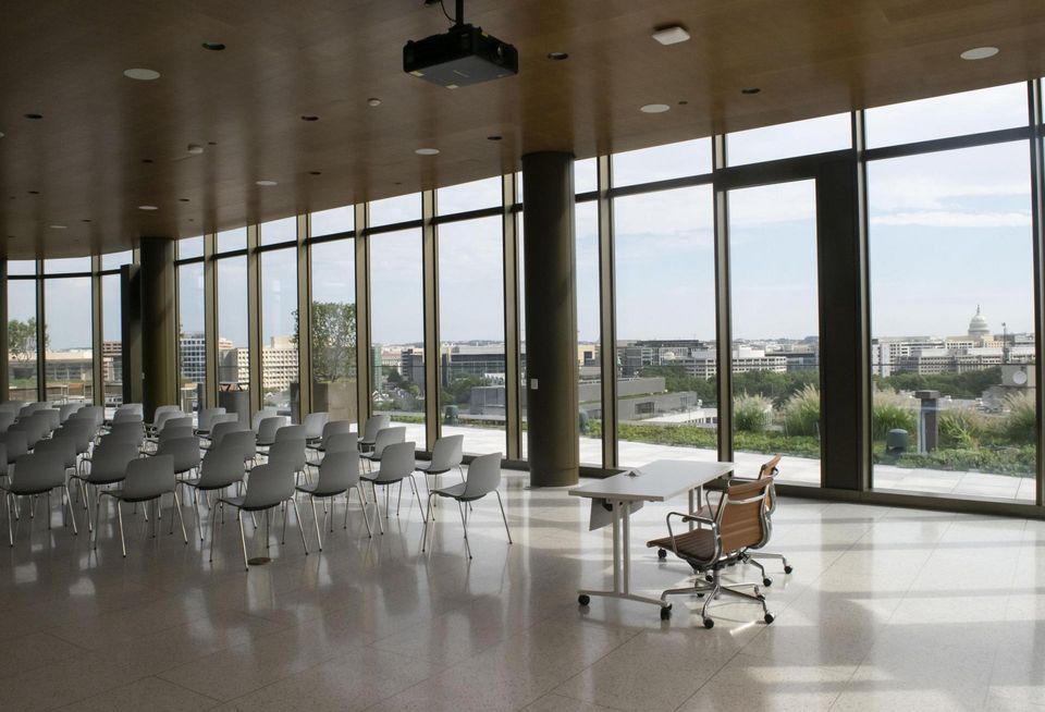 Interior of the 670 Maine Ave. shared conference rooms, which include a projector, seating and a view of the U.S. Capitol building