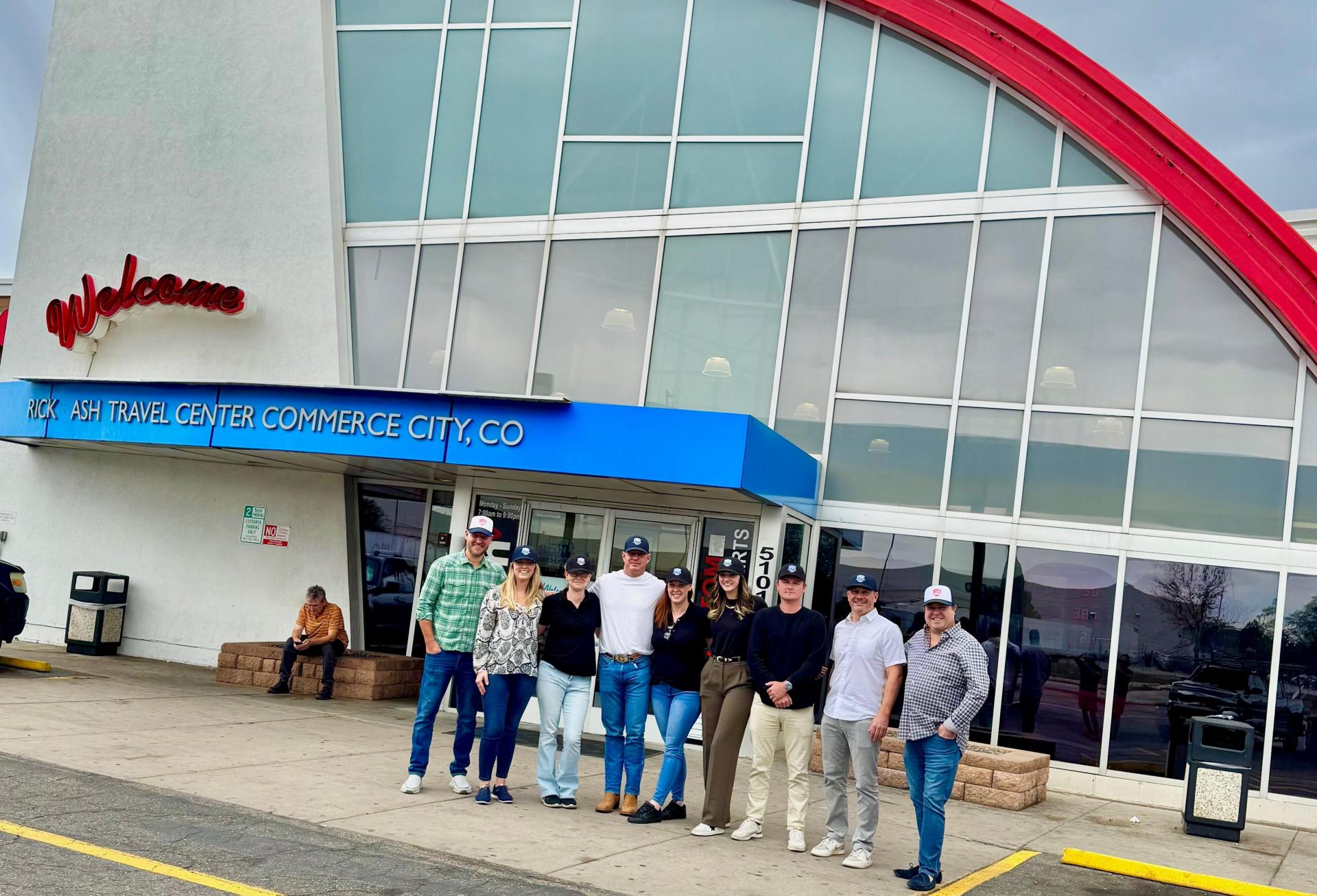 A photograph of the Good Investment Partners team outside the TravelCenter.
