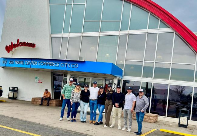 A photograph of the Good Investment Partners team outside the TravelCenter.