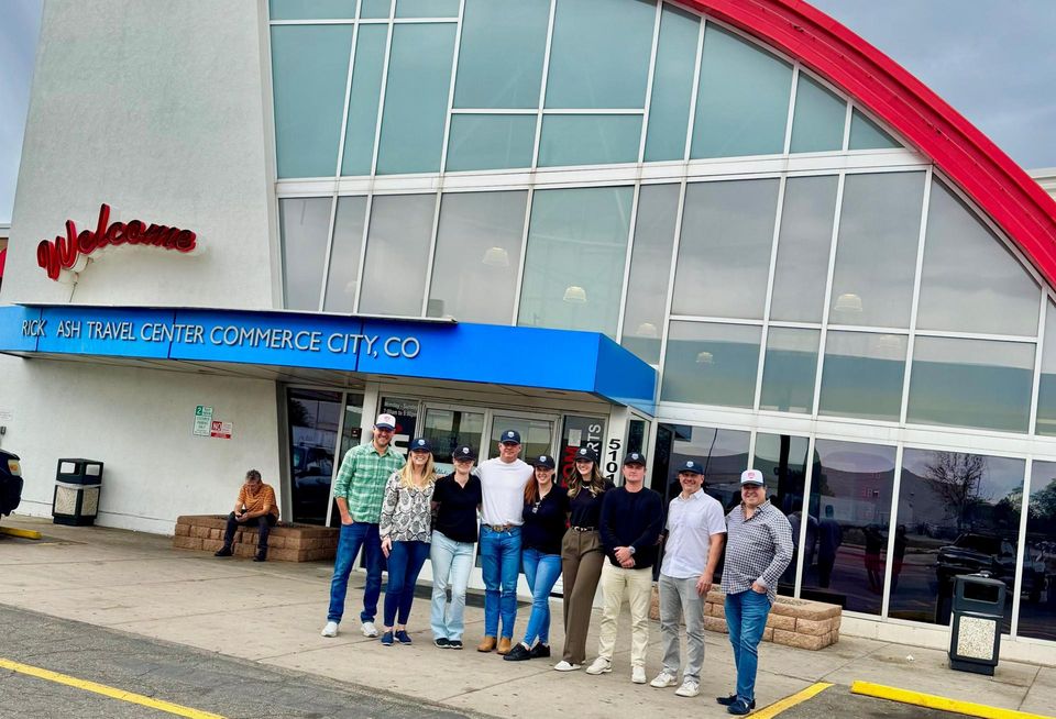 A photograph of the Good Investment Partners team outside the TravelCenter.