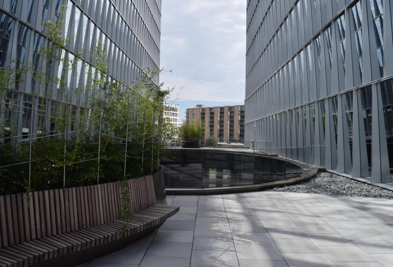 A terrace on top of The Oculus with a bench and view toward Maine Avenue SW. 