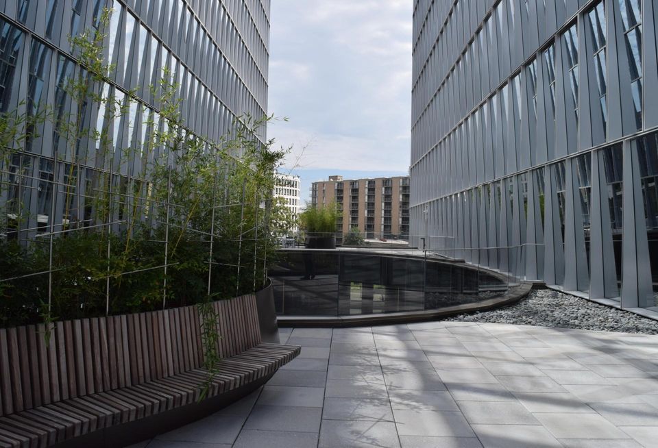 A terrace on top of The Oculus with a bench and view toward Maine Avenue SW. 