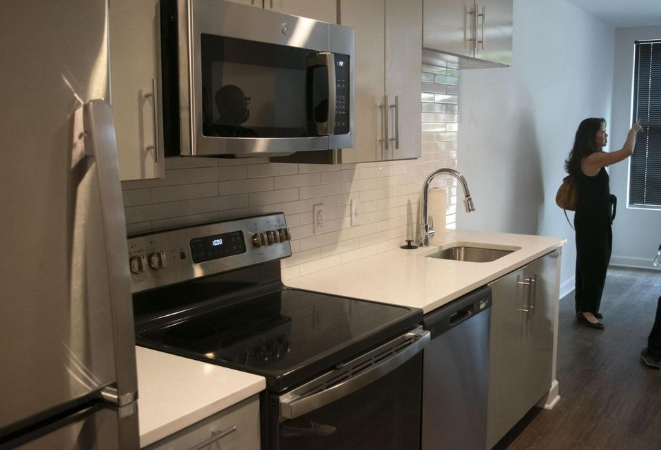 Jair Lynch Senior Vice President of Development Ruth Hoang shows off an apartment in Entwine. The kitchen features stainless steel appliances, including a refrigerator, microwave, oven, stove and dishwasher.