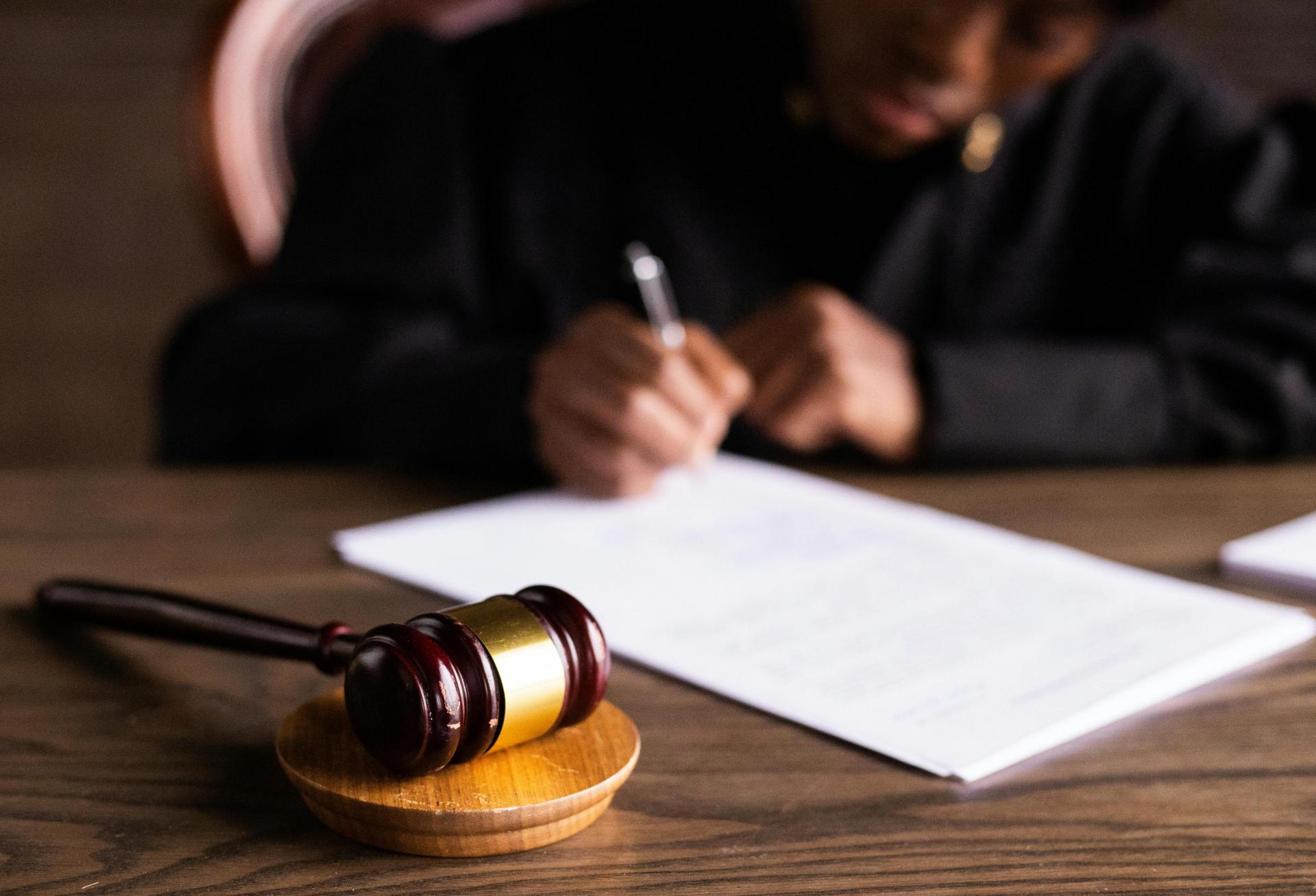 Judge writing behind a gavel. 
