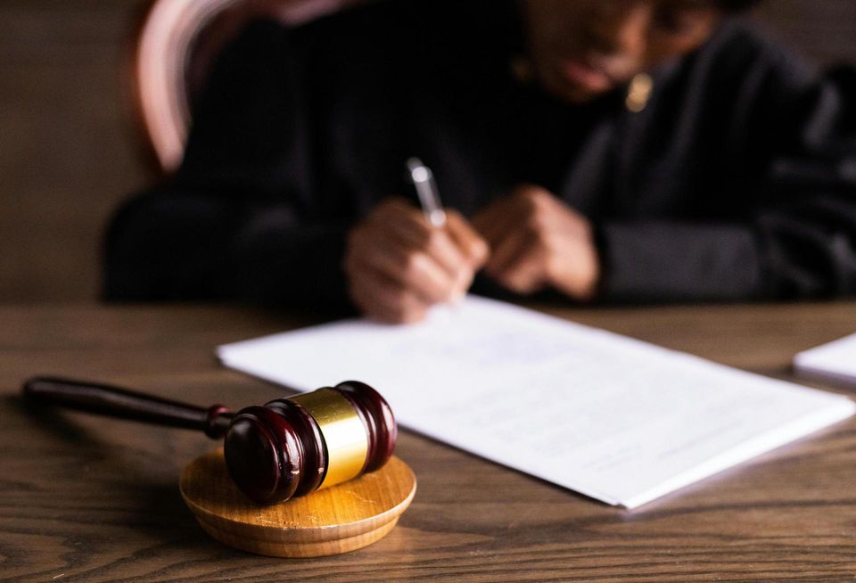 Judge writing behind a gavel.
