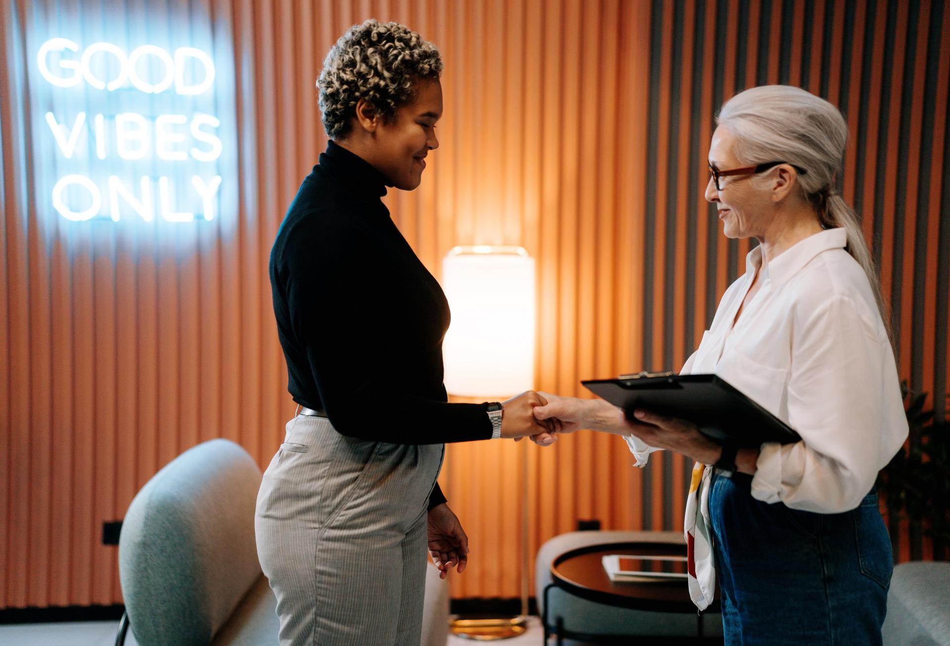 Two people shake hands following a job interview