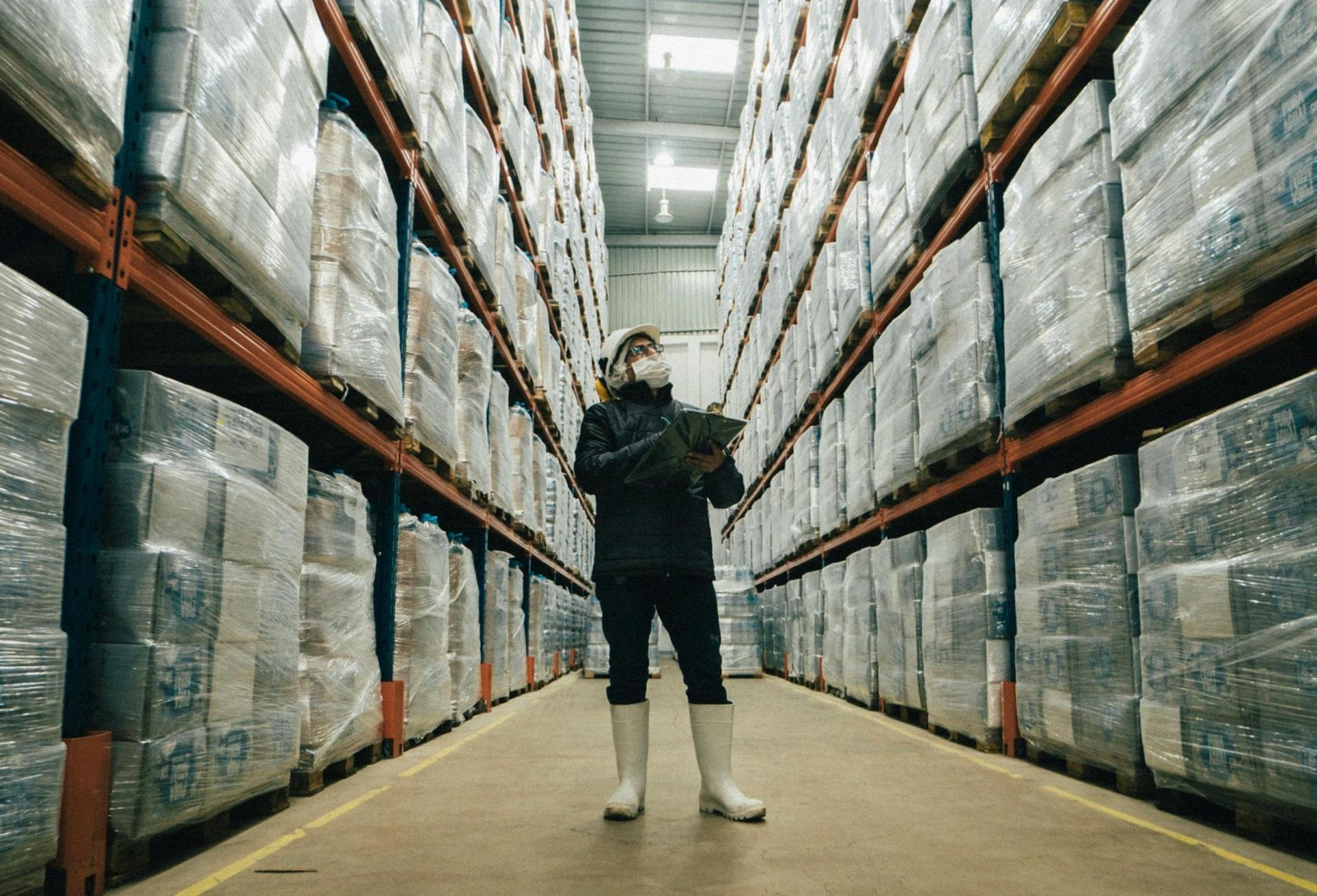 man in warehouse looking up distribution center 