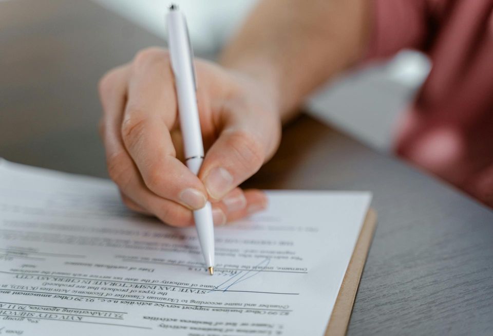 Person signing paper contract