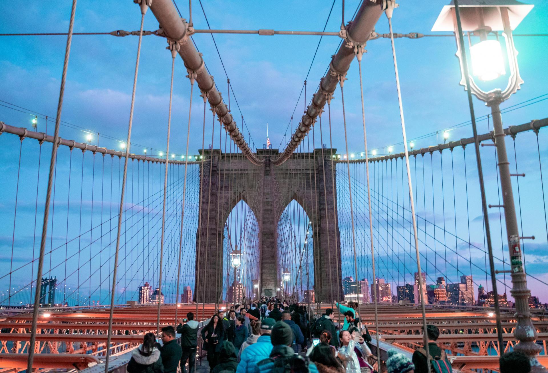 Tourists walking on the Brooklyn Bridge.