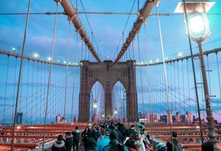 Tourists walking on the Brooklyn Bridge.
