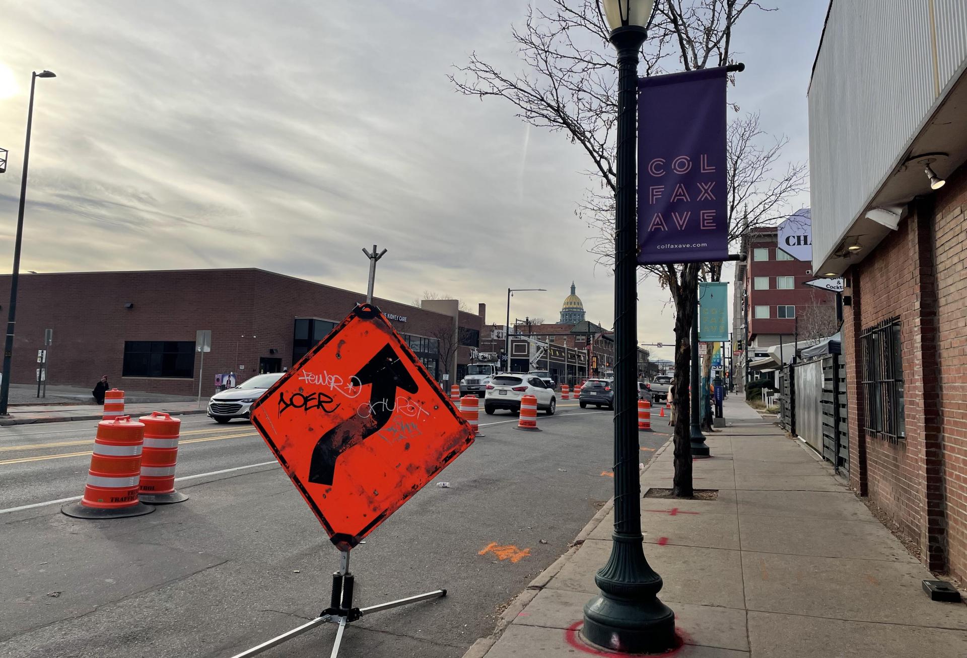 A view of East Colfax Avenue in Denver with street cones and closures for construction of the bus rapid transit system. The State Capitol can be seen in the background.