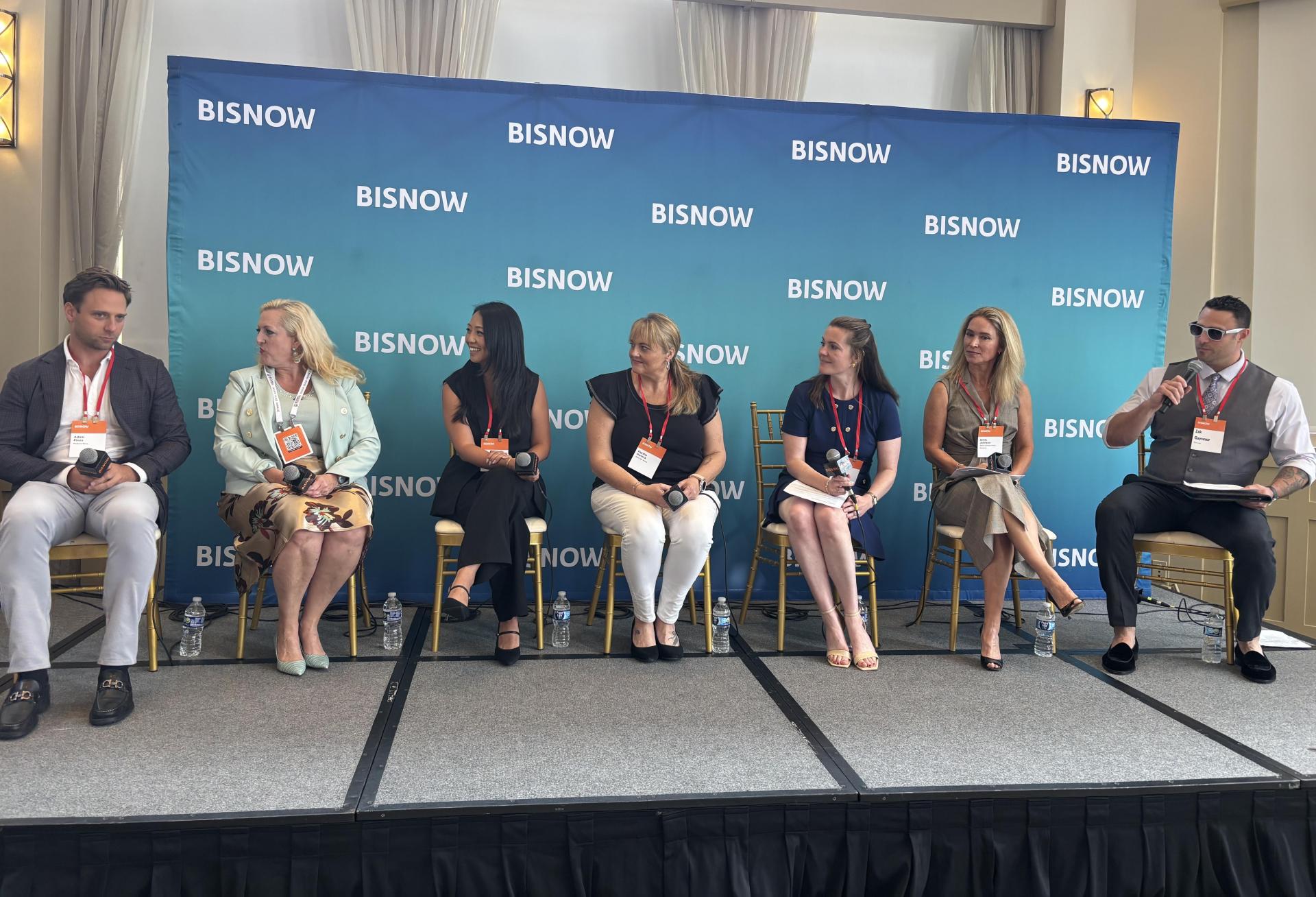 From left to right, speakers on a stage: Madison Rose's Adam Pines, Becknell Industrial's Paige Steers, Cushman & Wakefield's Sheila Acar, 1905 New Media's Kaysha Hanock, Stream Realty Partners' Marissa Rupert, Taylor Johnson Public Relations' Emily Johnson and Bisnow's Zak Guysenir.