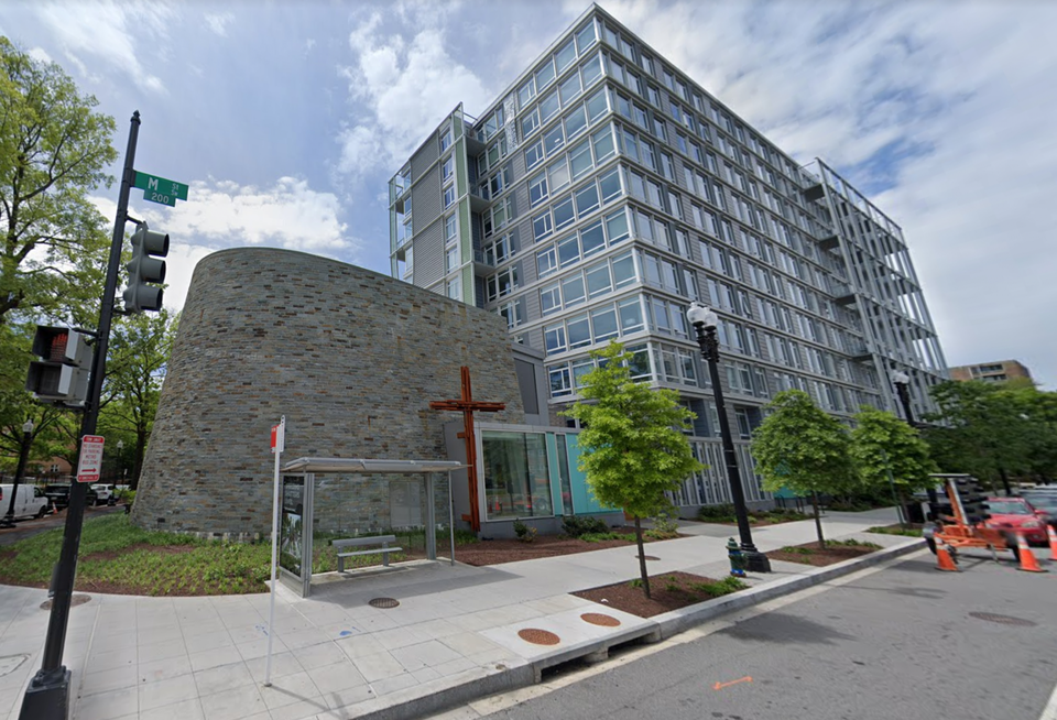 Corner property with a church with stone exterior connected to a multifamily residential building.