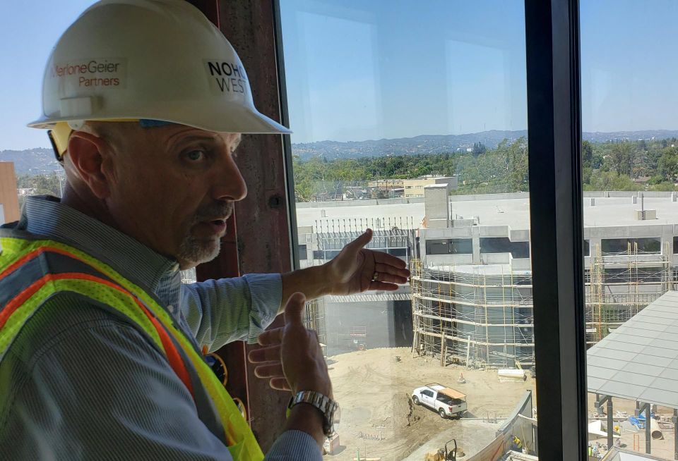 JLL's Patrick Church tours a Bisnow reporter at the construction of Merlone Geier's NoHo West project in North Hollywood