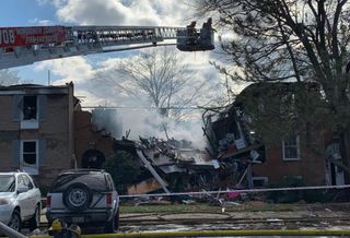 The scene of the fire at Potomac Oaks condominiums in Gaithersburg, Maryland. One building in the center of the photo is substantially collapsed, and the buildings on either side are also heavily damaged.