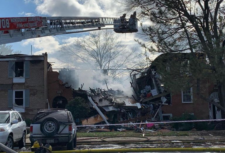 The scene of the fire at Potomac Oaks condominiums in Gaithersburg, Maryland. One building in the center of the photo is substantially collapsed, and the buildings on either side are also heavily damaged.