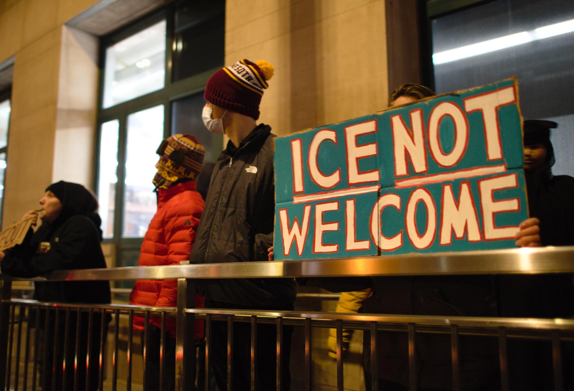 People holding a sign protesting ICE in Minnesota.