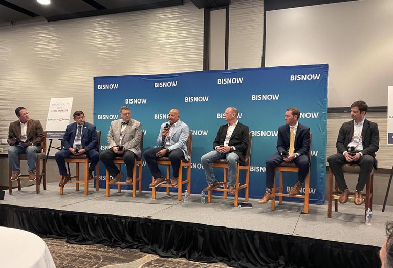 A photograph of panelists seated onstage discussing Colorado aerospace ecosystem