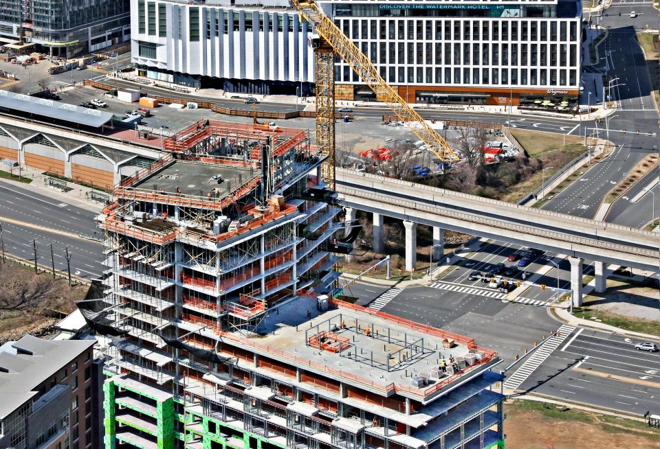 An aerial shot of the under-construction Heming apartment building, with Route 123 and Capital One Hall in the background