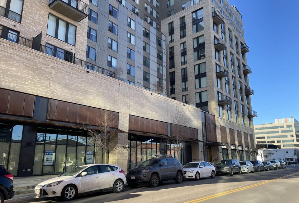 A photo of the Edit multifamily building up close, showing nearly an entire block's worth of vacant retail space.