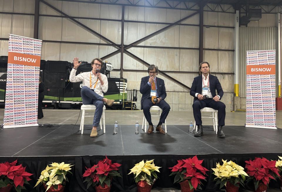 From left to right, sitting on a stage: Bisnow's Will Follett, IBT Group's Gary Pachucki and Envoi Partners' Nate Ernst.