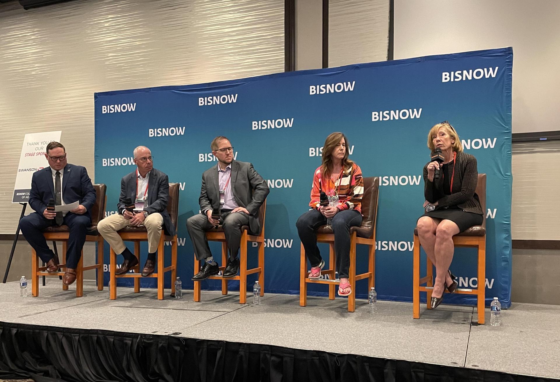A photograph of panelists seated onstage discussing Colorado aerospace ecosystem.
