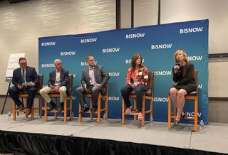 A photograph of panelists seated onstage discussing Colorado aerospace ecosystem.