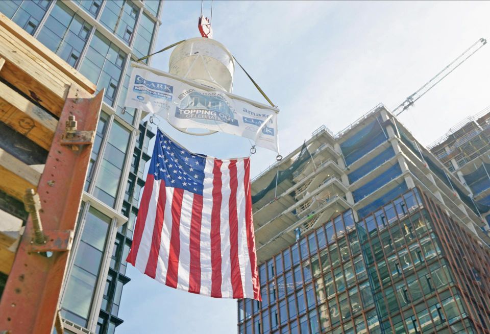 A flag is raised during a topping out ceremony for the Met Park 6/7/8 buildings, part of the first phase of Amazon's HQ2