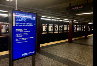A subway sign promoting congestion pricing