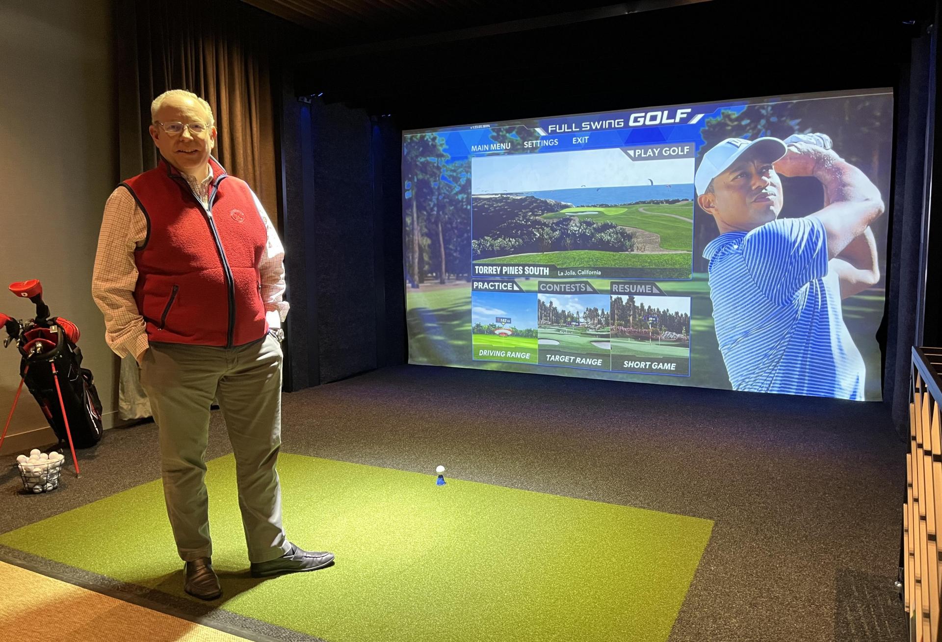 RXR's head of leasing, Bill Elder, on the green at 5 Times Square's golf simulator.