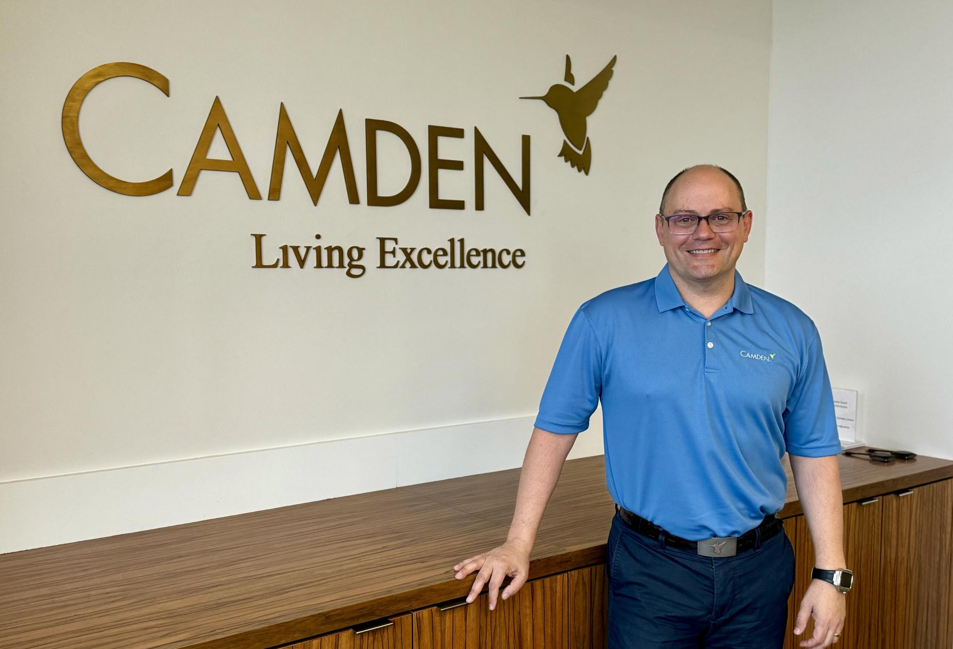 Alex Jessett standing in front of a Camden Realty Trust sign.