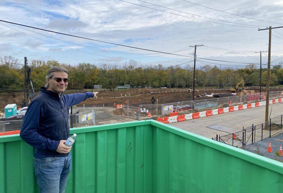 Tom Skinner, standing on the site of The Sandlot, points toward construction for The Douglass in the Bridge District