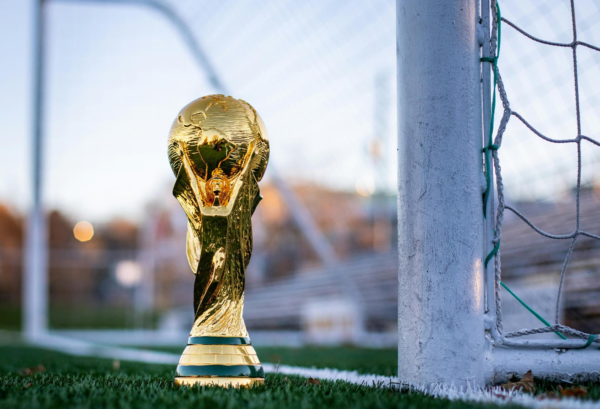 a golden soccer trophy sitting on top of a soccer field
