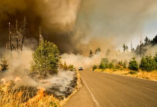 A car drives away from the Jones Fire, which burned thousands of acres in Massachusetts in 2017.