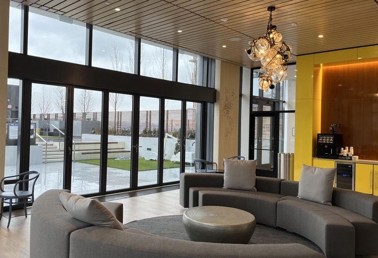 3eleven's amenities include a shared lounge, with custom art by Christina Watka, which opens onto an outdoor roof deck with a swimming pool.