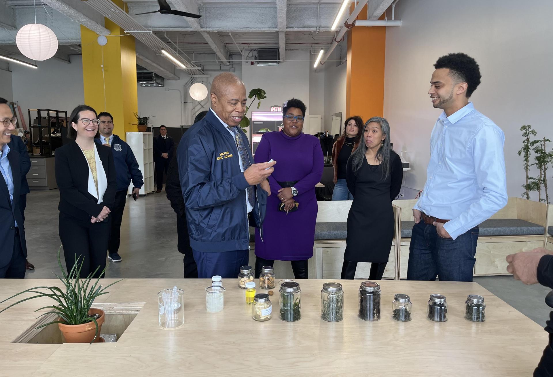 Mayor Eric Adams and Brooklyn Navy Yard President Lindsay Greene, in purple, on a tour of life sciences companies working out of the Navy Yard's Building 303 life sciences hub.