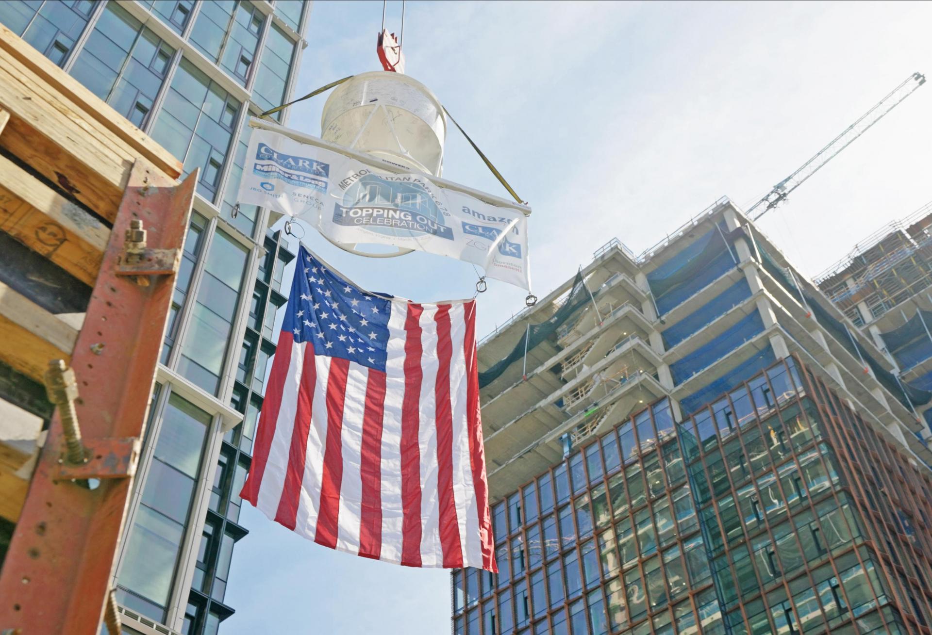 A flag is raised during a topping out ceremony for the Met Park 6/7/8 buildings, part of the first phase of Amazon's HQ2