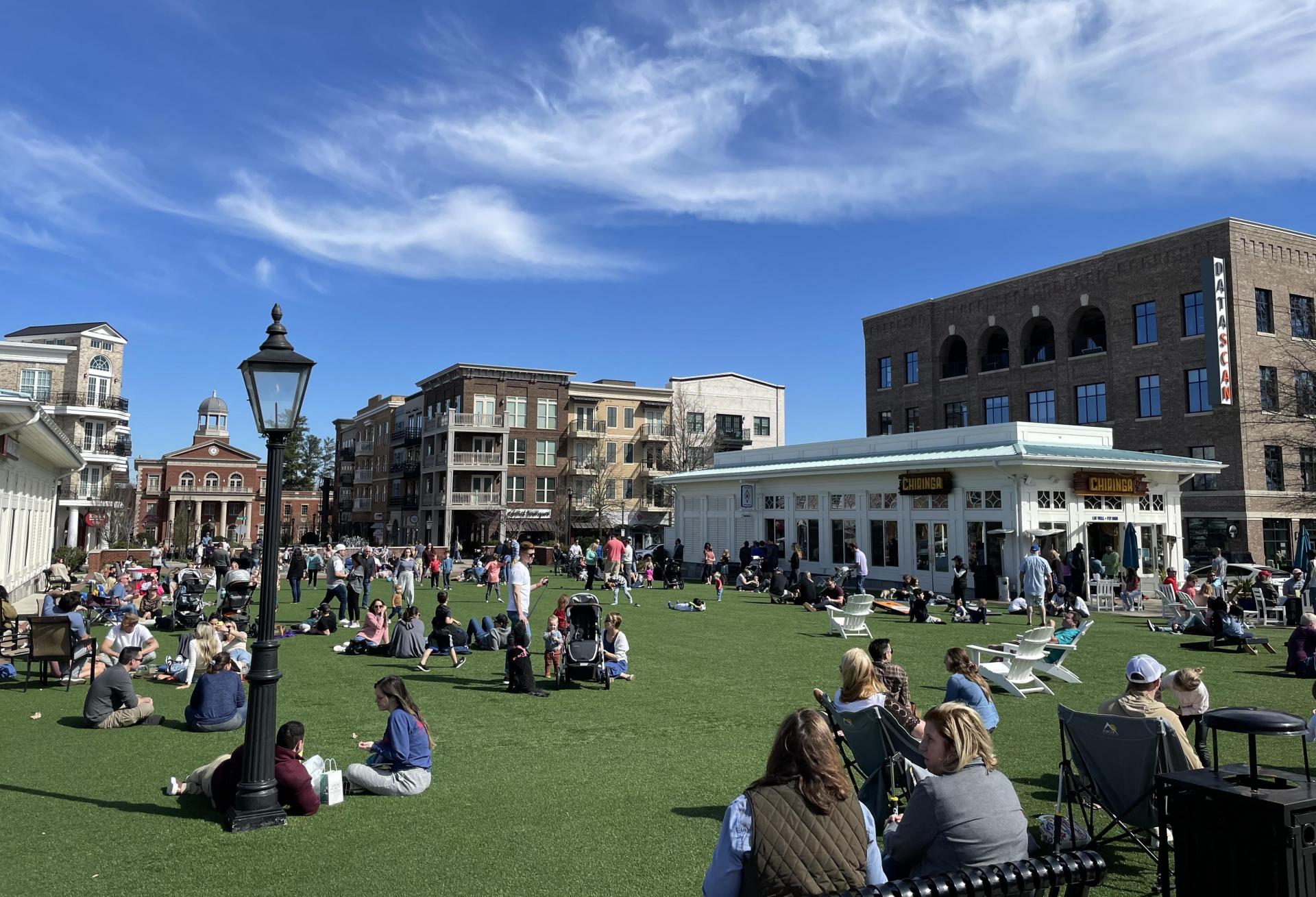 Cheri Morris developed Alpharetta City Center to encourage walkability by providing 11 points of pedestrian access, parks and open green space among other amenities. people lounging in a square