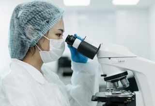 A person looking into a microscope