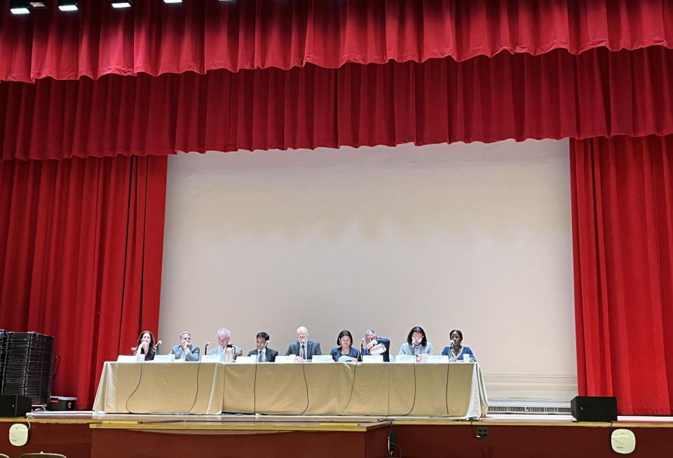 The nine members of the Rent Guidelines Board onstage in an almost-empty theater at Hunter College, while protests continued outside the building.