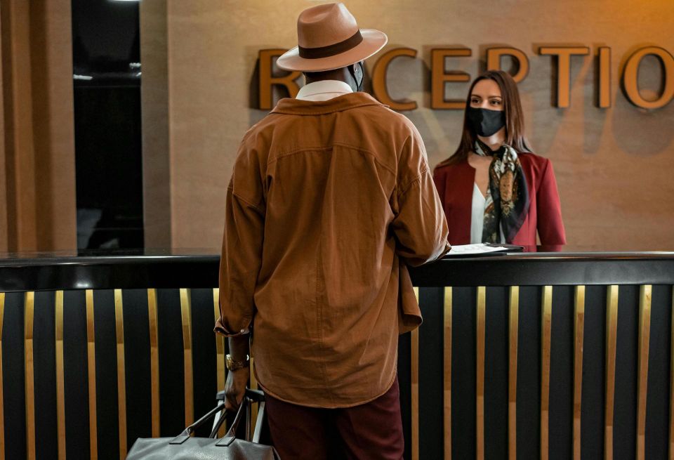 Person standing at a hotel reception desk
