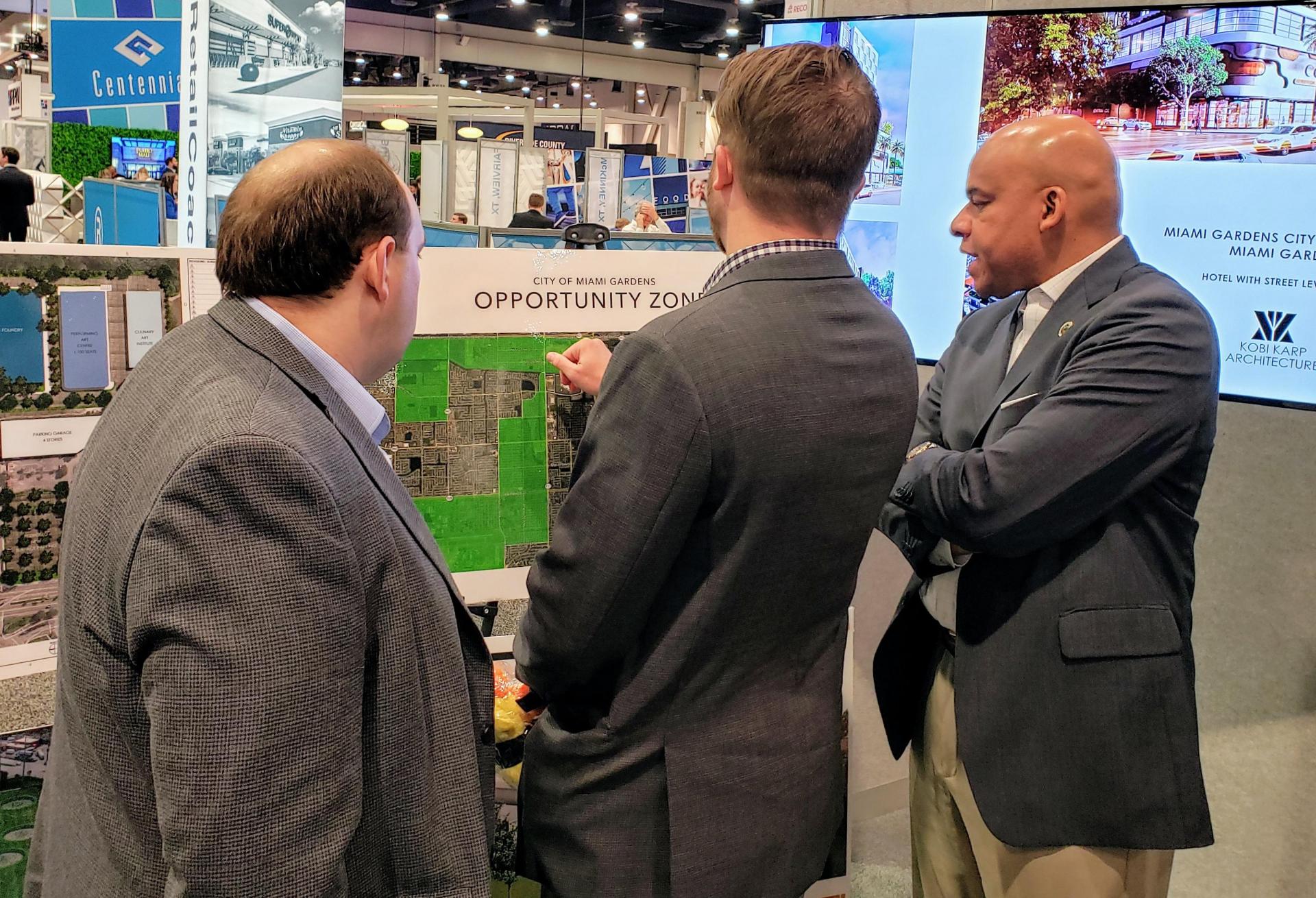 City of Miami Gardens Deputy City Manager Craig Clay talks to a couple of investors about the city's opportunity zone areas at ICSC RECon 2019.
